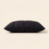 Direct horizontal side profile view of The Black Pillow Original showing its low minimalist neck alignment profile for back-sleepers.