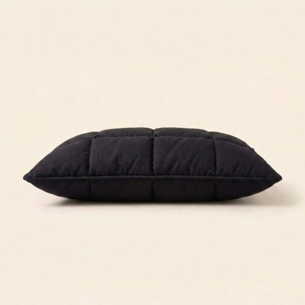 Direct horizontal side profile view of The Black Pillow Original showing its low minimalist neck alignment profile for back-sleepers.