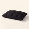 Perspective studio shot of The Black Pillow Original highlighting its plush volume and natural matte black texture.